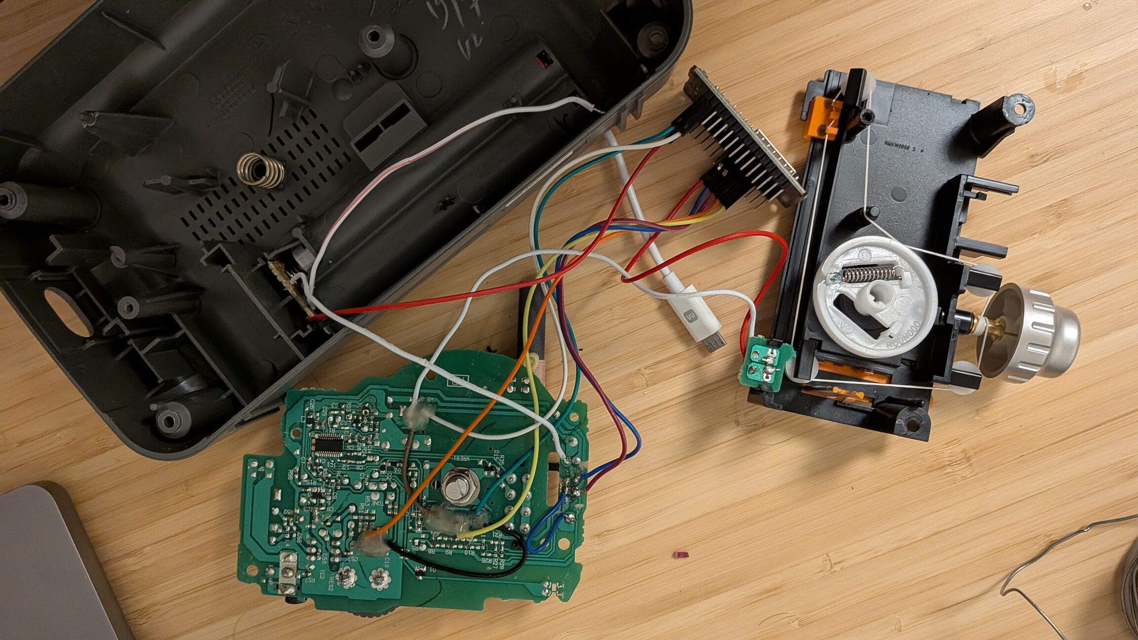 Disassembled radio: case shell, main PCB, and dial assembly